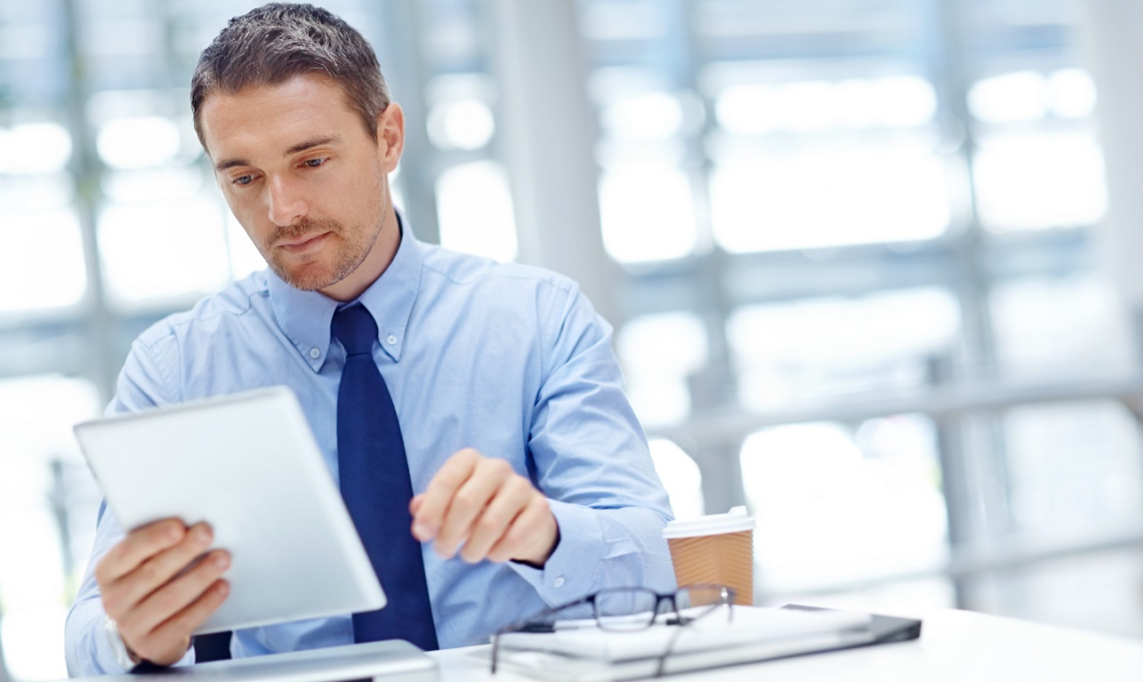 Businessman with tablet at office table